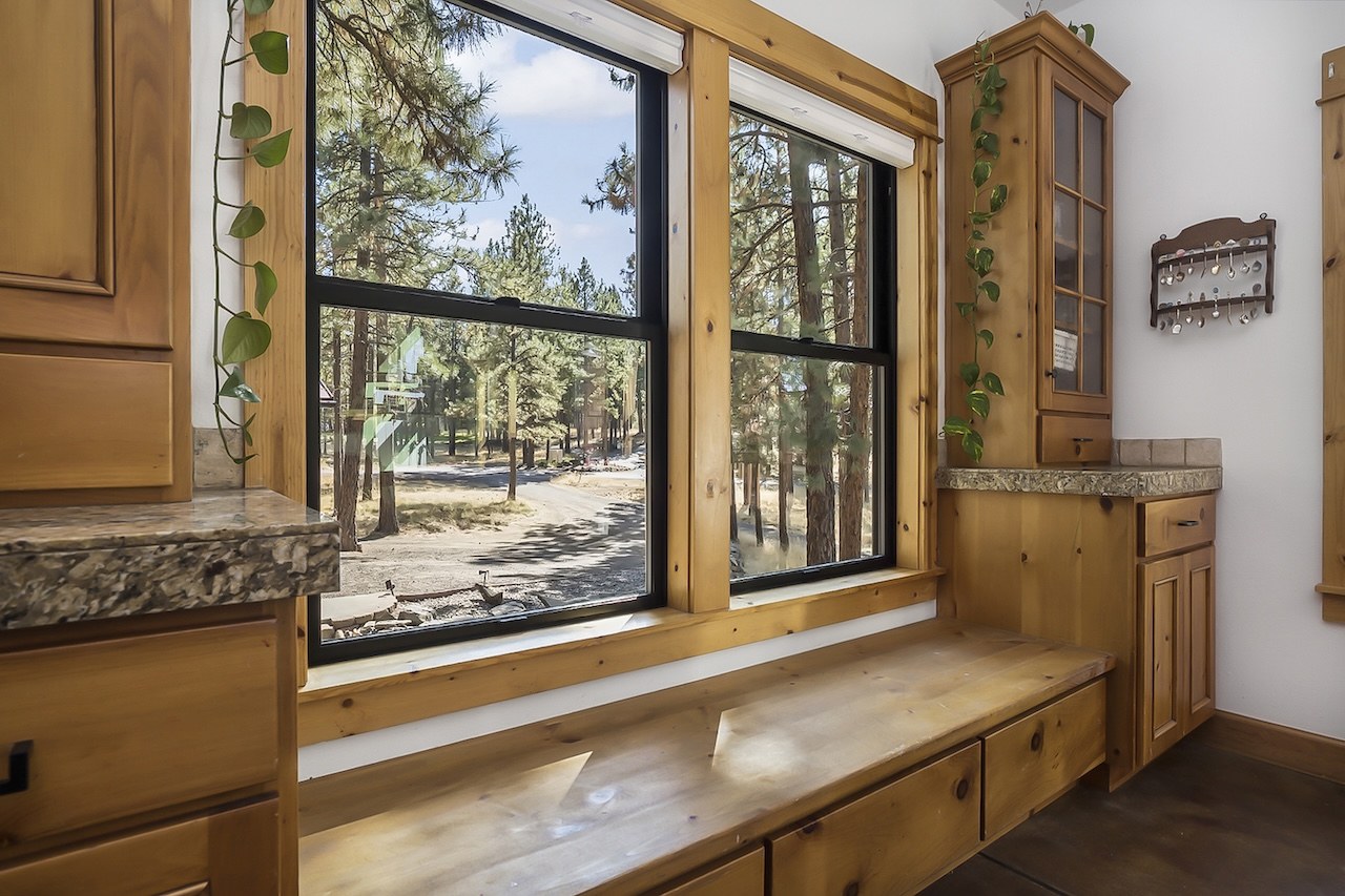 Wood-trimmed windows above a kitchen counter